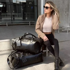 Model using the Mansfield Duffle Bag in black leather outdoors, showcasing its premium full-grain leather and durability.