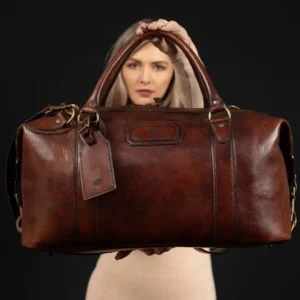 Model holding the Mansfield Duffle Bag in black leather, highlighting its spacious interior and vintage craftsmanship.