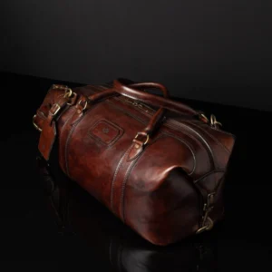 Angled artistic shot of Mansfield Duffle Bag in vintage brown leather, showcasing its rich patina and structured silhouette.