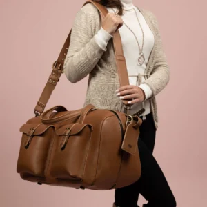 Women’s Marcella Overnight Duffle Bag in tan leather, carried by model, highlighting its elegant travel-ready aesthetic.
