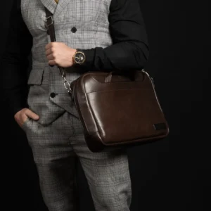 Model carrying the Astin Sleek brown leather laptop bag, highlighting its warm-toned full-grain leather and modern structure.