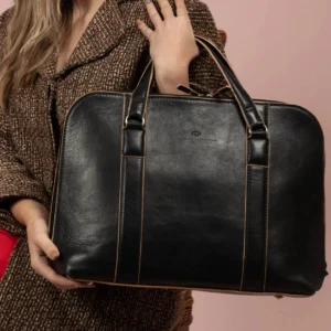A model holds the women's Reagan Euro black leather laptop bag, showing its structured design and silver hardware.