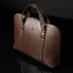 Reagan Euro brown leather laptop bag standing upright, highlighting its structured design and reinforced leather handles.