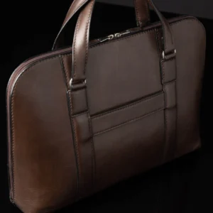 Back view of Reagan Euro brown leather laptop bag, featuring a luggage strap for easy suitcase attachment.