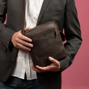 Men's brown Montrose Sling Bag, styled on a male model, showcasing its premium leather craftsmanship and adjustable strap.