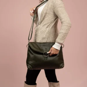 Model carrying Women's Monroe 2-in-1 bag in olive green leather as a sling bag, featuring an adjustable strap and stylish design.