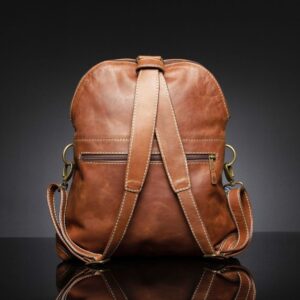 Back view of Women's Monroe 2-in-1 bag in rich brown leather, showing backpack straps, zippered compartments, and stitching details.