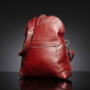 Women's Monroe 2-in-1 leather bag in ruby red, standing upright with its structured design and reinforced stitching.