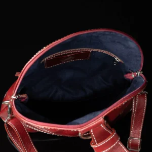 Interior view of Women's Monroe 2-in-1 bag in ruby red leather, highlighting the spacious compartments, card slots, and zippered sections.