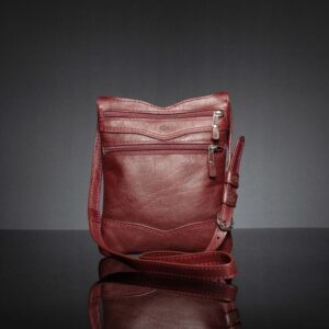 Women's Dakota Sling Bag in ruby red, highlighting the Charles Lansdown logo and front zip pockets.