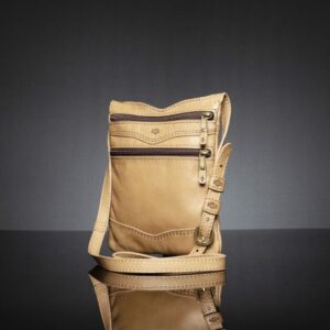Side angle of Women's Dakota Sling Bag in tan, showing its slim profile, secure zippers, and elegant leather finish.
