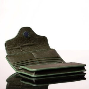 Inside compartments of an olive green leather Genevieve purse, featuring dual zip compartments, 12 card slots, and a magnetic flap closure.
