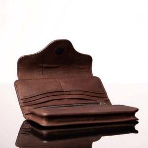Inside compartments of a rich brown leather Genevieve purse, including an expanding pouch, multiple storage slots, and a secure magnetic flap closure.
