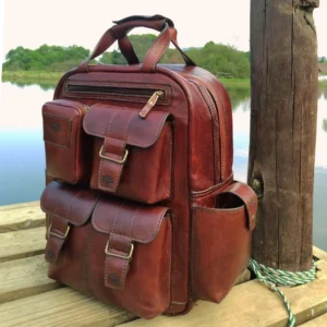 The Franklin leather backpack displayed in a tranquil outdoor setting, highlighting its rich polished brown leather and vintage appeal.