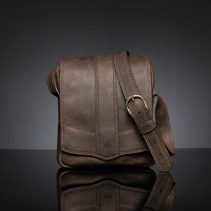 Indiana men's leather sling bag in brown with a refined silhouette and durable brass hardware.