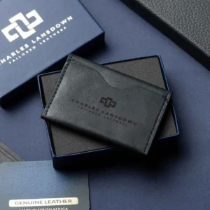 Men’s black leather bifold cardholder on a luxury gift box. Handcrafted full-grain leather with curved slots for sleek storage.