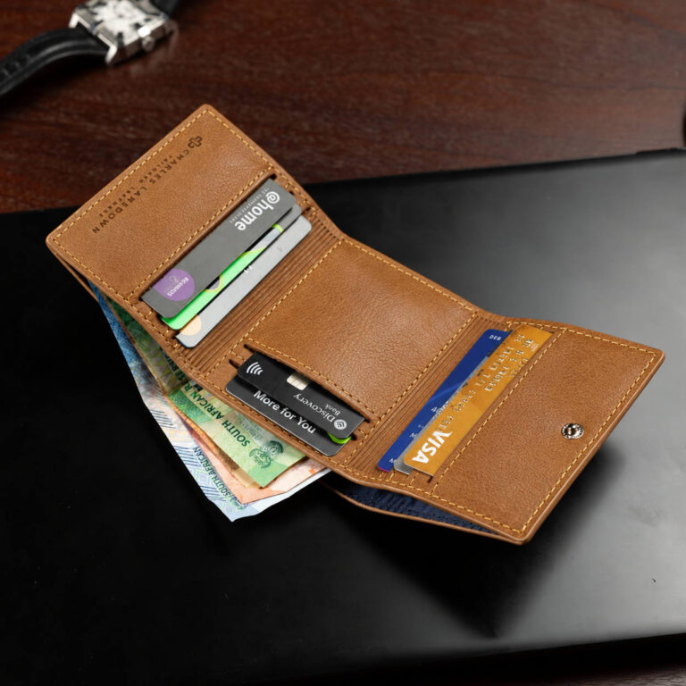 CHARLES LANSDOWN Ashford leather trifold wallet in rich tan, lifestyle view.