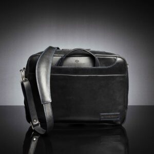 Front view of Astin Sleek black leather laptop bag, showcasing its detachable leather shoulder strap for versatile carrying.
