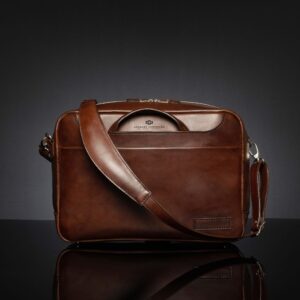 Astin Sleek polished brown leather laptop bag with handles tucked in, showcasing its sleek and compact design.