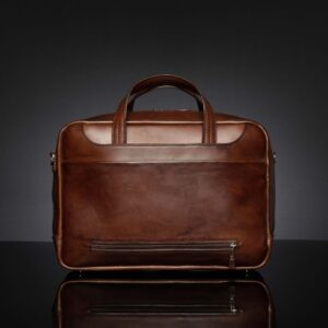 Back view of Astin Sleek polished brown leather laptop bag, featuring a bottom zipper that opens for secure suitcase attachment.