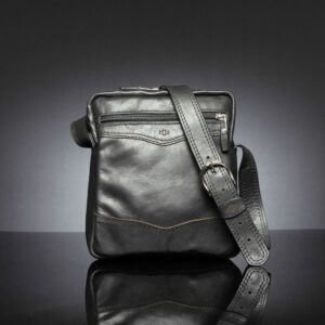 Montrose Sling Bag in black leather, featuring a zippered front pocket and structured design.