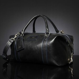 Angled view of Mansfield Duffle Bag in black leather, showcasing its reinforced leather handles and sleek silhouette.