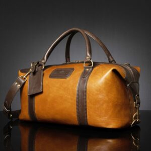 Angled view of Mansfield Duffle Bag in tan and brown leather, showcasing its structured form and premium finish.