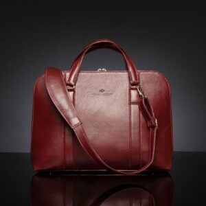 Women's Reagan Euro ruby red leather laptop bag, featuring a detachable shoulder strap for multiple carrying options.
