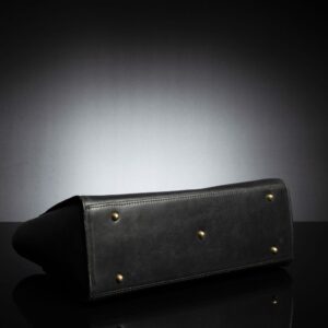 A detailed shot of the structured base and gold feet of the Aria Tote, ensuring stability when placed on surfaces.