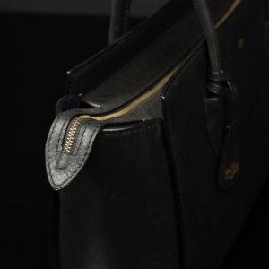 Close-up of the Aria Tote Laptop Bag’s gold-tone metal zip and leather detailing.