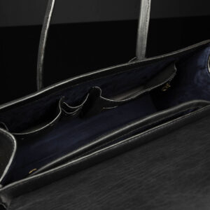 Interior view of women's black leather laptop tote bag, showcasing compartments and padded laptop sleeve.
