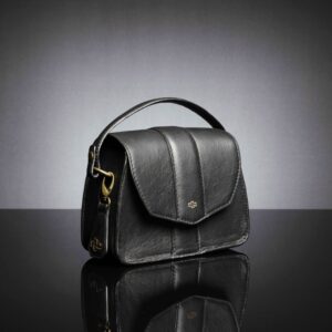 Women's Belle genuine leather side bag in black, shown from a side angle with its structured design and removable arm strap.