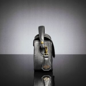 Belle black leather side bag with structured handle, showcasing its elegant forearm carry option.