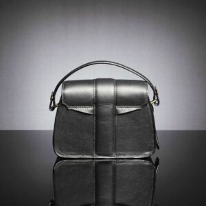 Back view of the women's Belle black leather bag with only the handle, highlighting its refined, minimalist design.