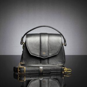 Women's Belle black leather bag with forearm strap, showing versatility and detachable sling strap.