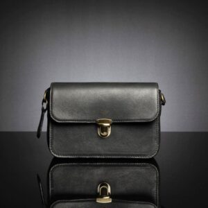 Women's Cressida Black leather sling bag with a refined rectangular shape and soft, full-grain leather texture.