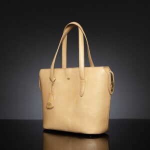 Side view of the women's tan leather Natalia tote bag highlighting its sleek design and durable handles.