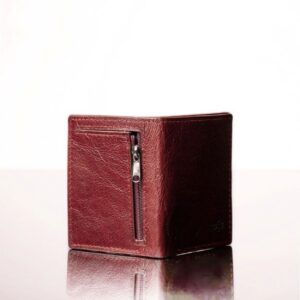 Close-up of the back of a ruby red leather mini purse, featuring a back zip compartment where coins can be stored.