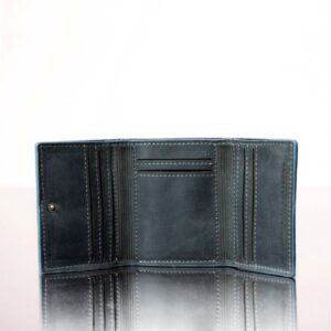 Inside compartments of a denim blue leather trifold purse, showcasing multiple card slots, a coin pouch, and bill storage.