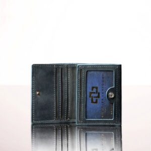 Denim blue trifold leather purse slightly open, revealing organized compartments for everyday essentials.
