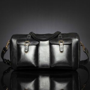 Marcella Overnight Duffle Bag in black full-grain leather, featuring a structured silhouette and antique brass fittings.