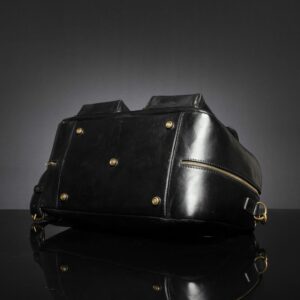 Bottom view of Marcella Overnight Duffle Bag in black leather, showcasing protective brass feet for durability.