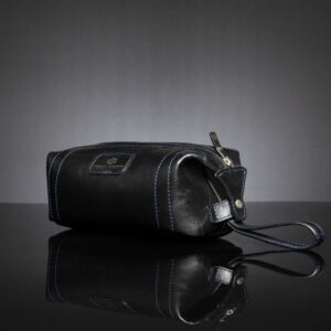 Side view of Mansfield Toiletry Bag in black leather, showcasing the press-stud opening for easy access.