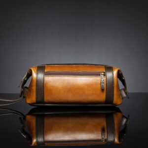 Back view of Mansfield Toiletry Bag in brown and tan leather, featuring a zippered storage compartment.