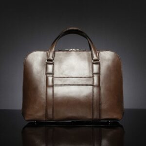 Back view of Reagan Euro brown leather laptop bag, featuring a luggage strap for easy travel attachment.