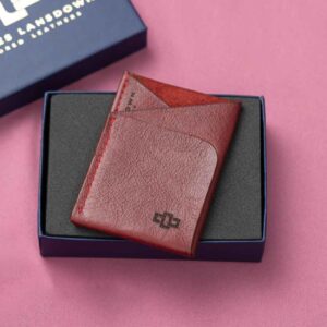 A bold ruby red leather cardholder with a sleek geometric design, beautifully presented in a luxury gift box.