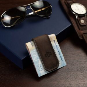 Brown leather money clip displayed on a luxury surface, emphasizing its strong magnetic clasp and fine craftsmanship.