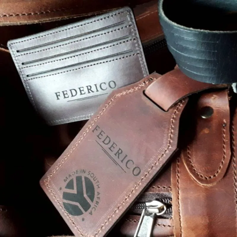 An individual recipient name engraved on a leather cardholder and luggage tag